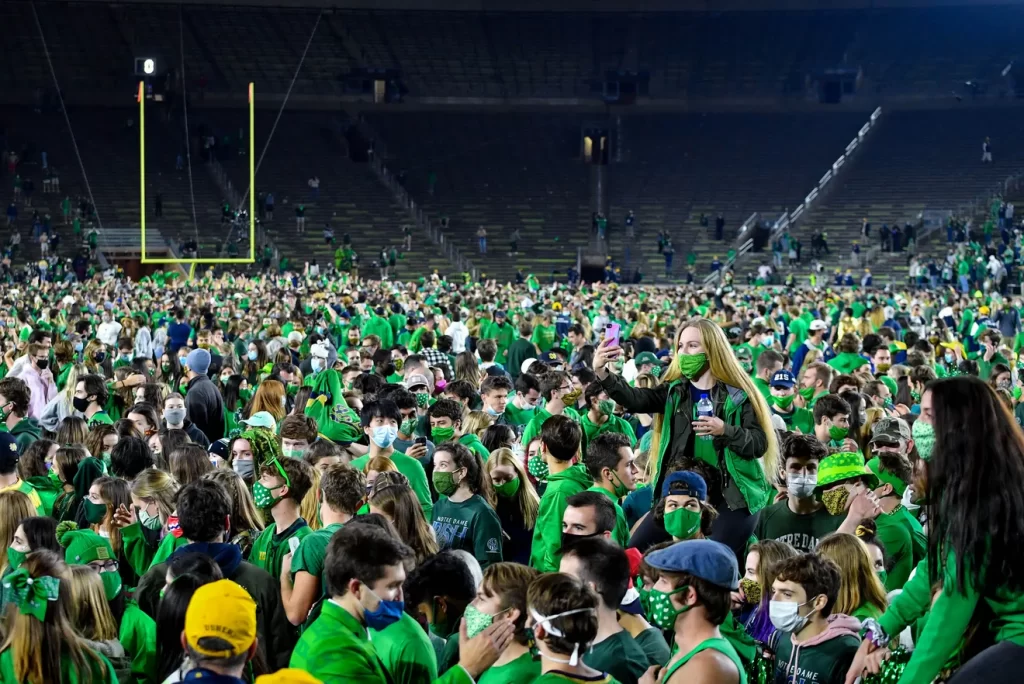 Notre Dame students storm the field after the football team upsets Clemson