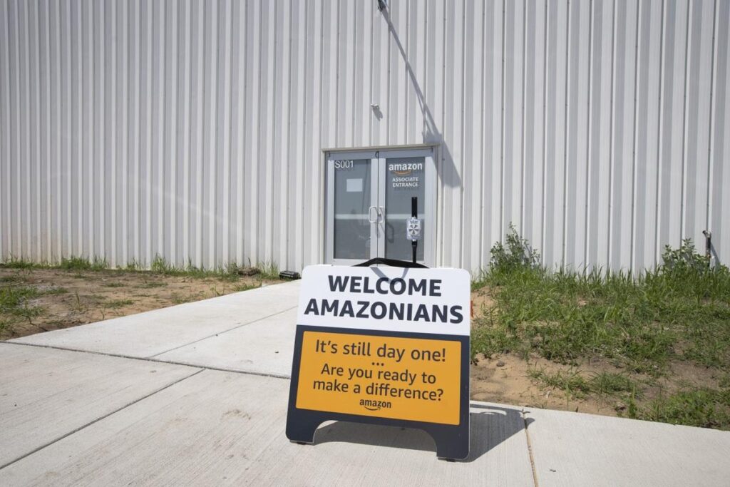 A sign reads Welcome Amazonians 
It's Still day one! ... Are you ready to make a difference? Amazong