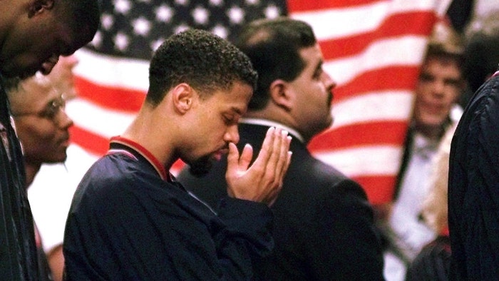Mahmoud Abdul-Rauf stands and prays during the national anthem